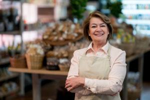 Latin American woman working at the supermarket - small business concepts