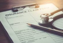 health insurance claim form with stethoscope on wood table