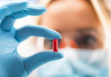 Pharmacist holding red pill