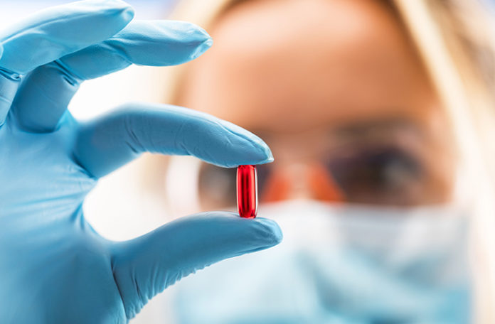 Pharmacist holding red pill