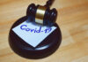 Judges gavel or law mallet and word covid-19 on sound block